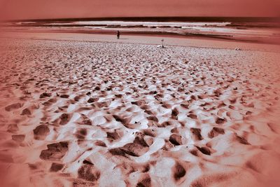 Text on sand at beach against sky