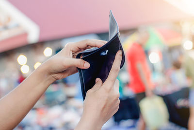 Close-up of woman holding empty wallet outdoors