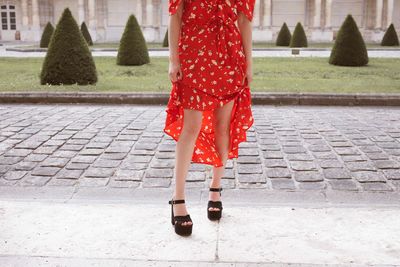 Low section of woman standing on footpath