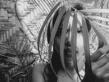 Close-up portrait of young woman holding plant