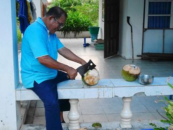 Side view of man preparing food on table