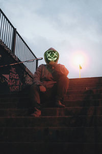 Low angle view of person on staircase against sky