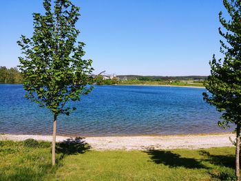 Scenic view of lake against clear blue sky