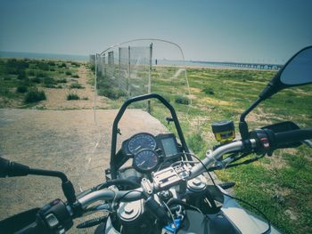 Close-up of motorcycle on road against sky