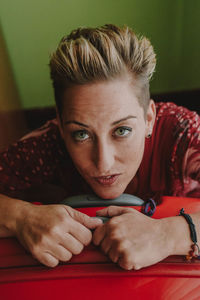 Close-up portrait of woman with suitcase at home