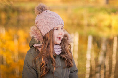 Little girl on yellow leaves background. girl in autumn forest. cute adorable child  in autumn park