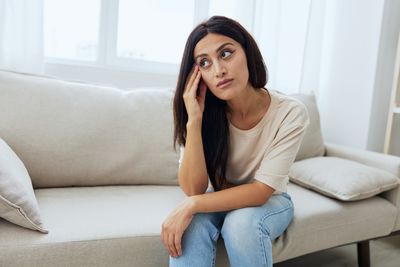 Young woman sitting on sofa at home