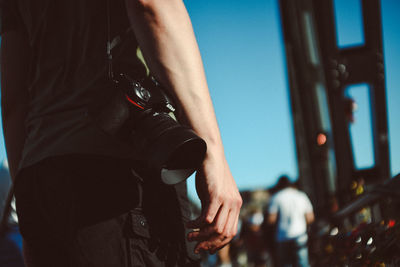 Midsection of man holding hands standing outdoors