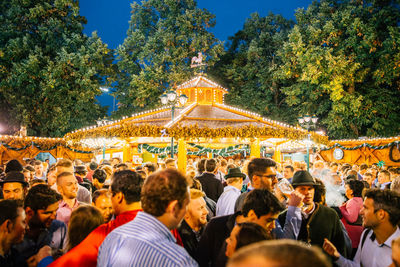 Crowd by illuminated gazebo at dusk