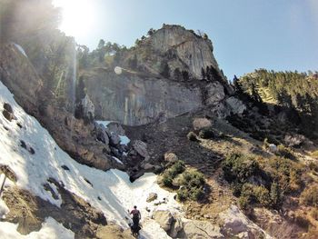 People walking on rocks against mountain range