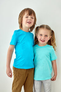 Portrait of cute kids standing against white background