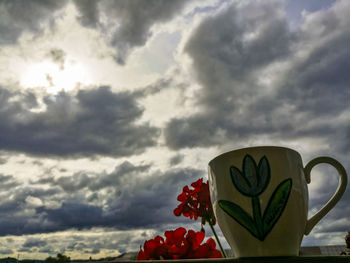 Heart shape made from coffee cup against sky