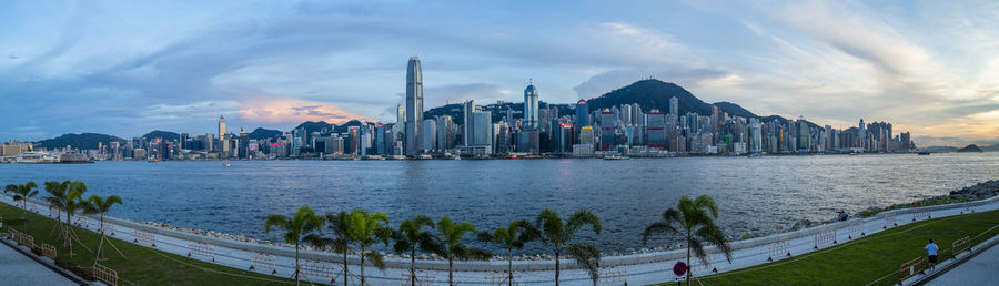 Panoramic view of buildings by river against sky