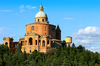 Low angle view of trees and buildings against sky