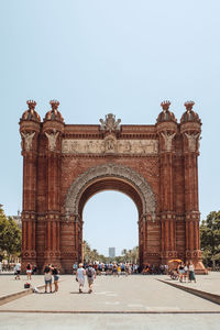 Group of people in front of historical building arco de triunfo barcelona