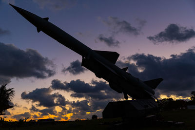 Low angle view of silhouette airplane against sky during sunset