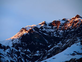 Low angle view of snow on mountain against sky