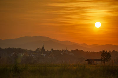 Scenic view of landscape against orange sky