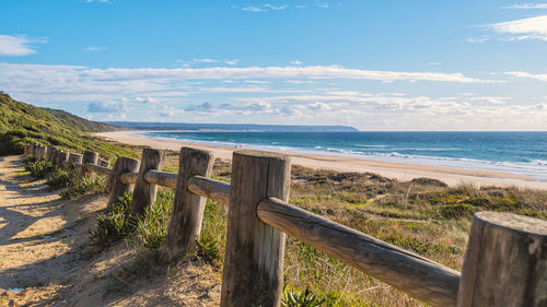 Wooden post on beach against sky