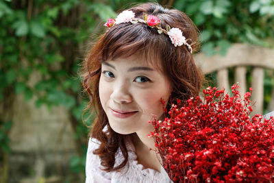 Portrait of happy woman with red flower