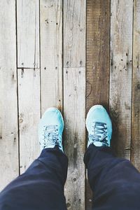 Low section of person standing on wooden floor