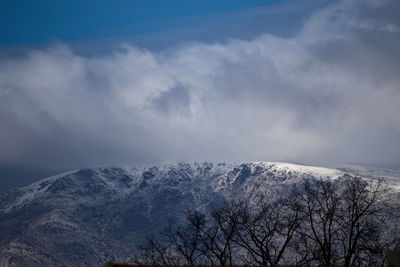 Low angle view of snowcapped mountains against sky