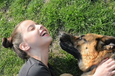 Close-up of happy woman with dog on grass