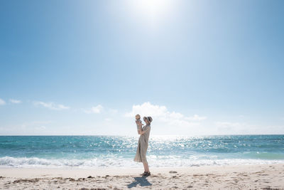 Full length of man standing on beach against sky