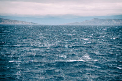 View from a ship on the windy sea with islands in the background