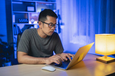 Young man using digital tablet at table