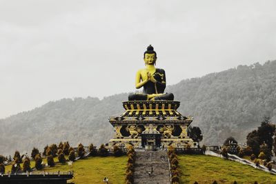 Statue in temple against sky