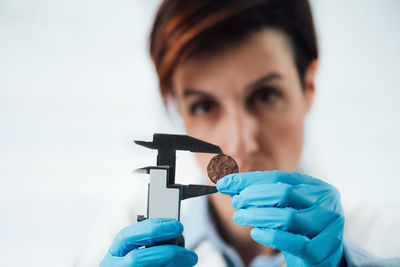 Numismatics expert in a museum research center identifying and documenting coin collection