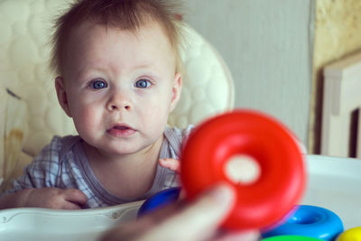 Cropped image of mother playing with cute son on high chair at home