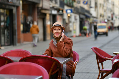 Portrait of young woman sitting on chair