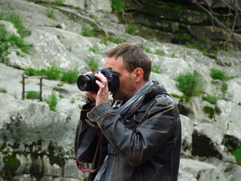 Man photographing while standing outdoors