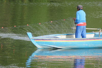 Rear view of man fishing in lake