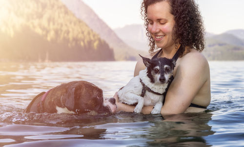 Portrait of young woman with dog in water