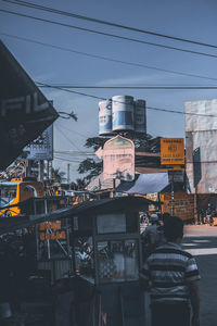 Cars on street in city against sky