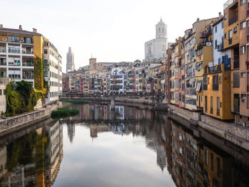 Reflection of buildings in canal against sky