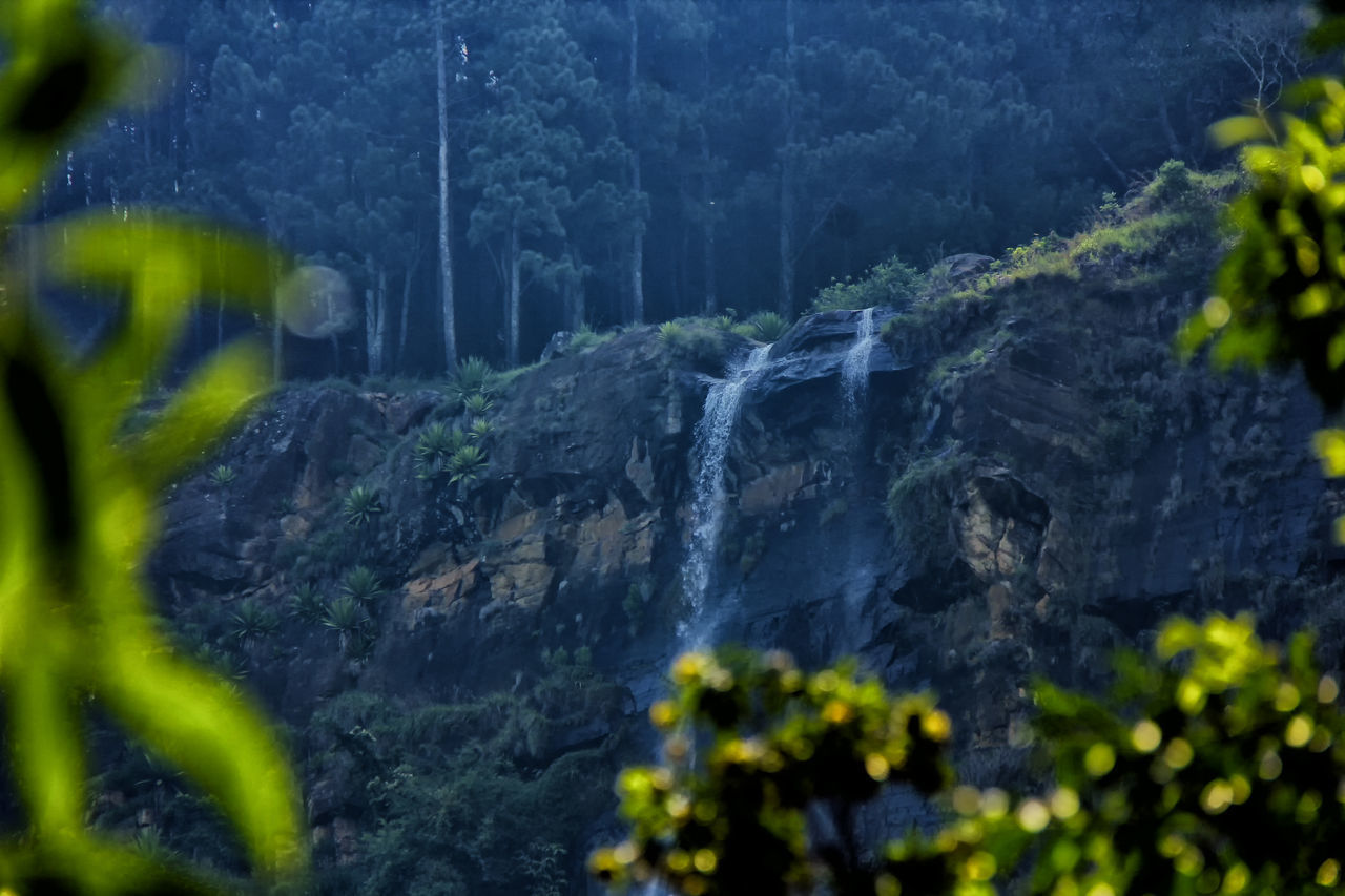 SCENIC VIEW OF WATERFALL AGAINST ROCKS