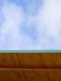 Low angle view of roof against cloudy sky