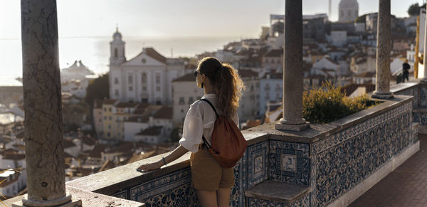 Woman standing by buildings in city