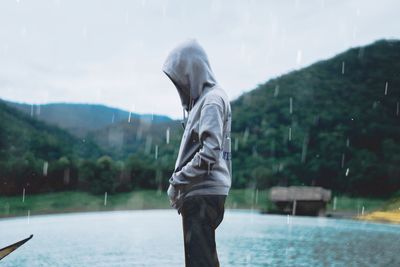 Man standing by lake against mountain