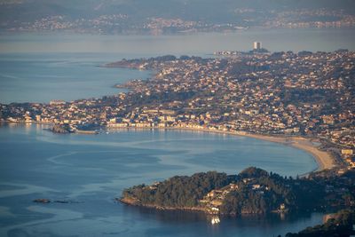 High angle view of city by sea against sky