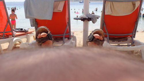 Low section of man relaxing on beach