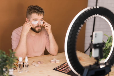 Portrait of young man using mobile phone at home