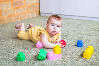 Candid lifestyle portrait of little girl. child playing with soft plastic colorful constructor.