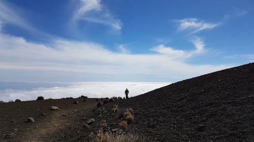 People standing on land against sky