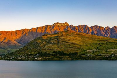 Scenic view of lake and mountains against clear sky