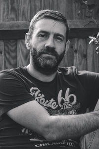 Portrait of senior man sitting against wall